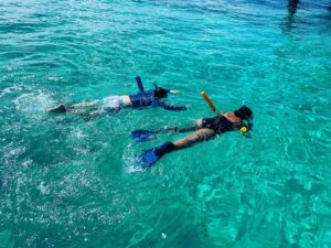 Two people snorkeling amid vibrant coral reefs in Islamorada, Florida, showcasing snorkeling tips for a safe and fun underwater experience.
